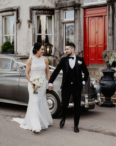 Newlywed couple with vintage sports car at Irish castle wedding venue
