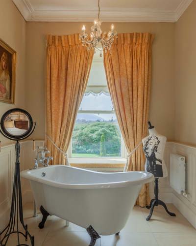 Luxury 4 star hotel room bathroom with garden views and 4 leg bath