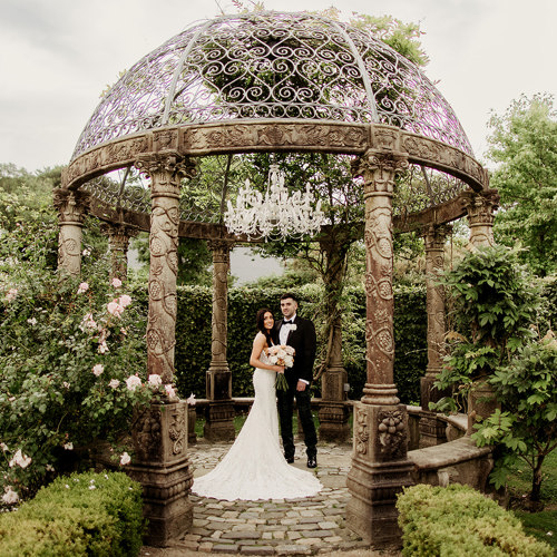 Newlywed couple stand inside garden pavillion at ballyseeded country estate and castle