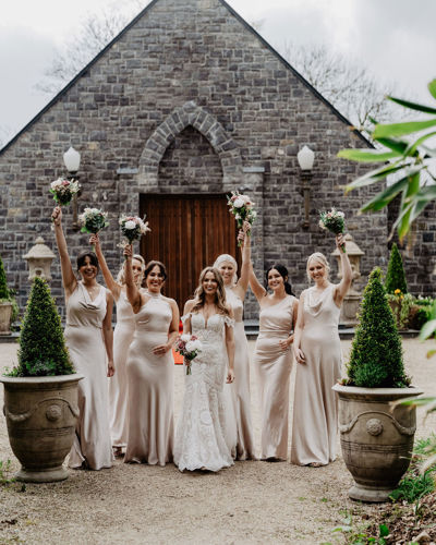 Bridge & Bridesmaids ourside wedding chapel at castle hotel wedding venue in kerry