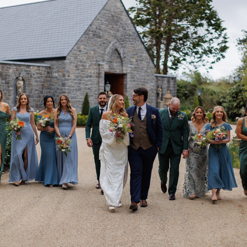 Couple stroll with wedding party at irish country estate wedding venue