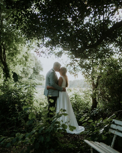 Couple kiss on their wedding day in the country estate gardens at ballyseede