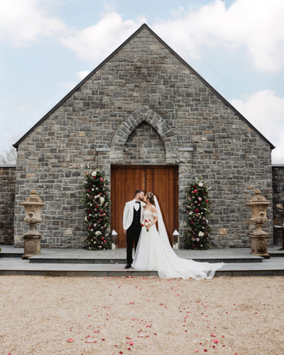 Wedding chapel in irish hotel as couple kiss outside