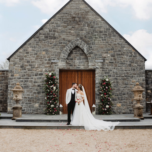 Wedding chapel in irish hotel as couple kiss outside