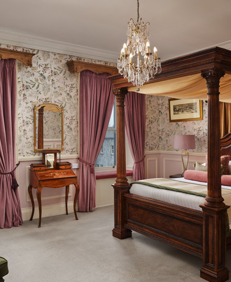 Luxury castle hotel room with chandelier and four post bed