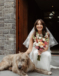 Bride pats dog outside castle chapel in ballyseede
