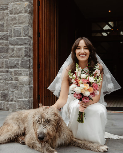 Bride pats dog outside castle chapel in ballyseede
