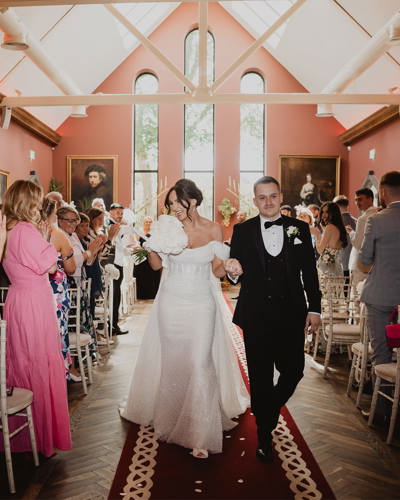 Couple walk down the aisle on their wedding day at irish castle wedding venue