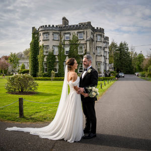 Couple embrace outside ballyseede castle wedding venue in kerry