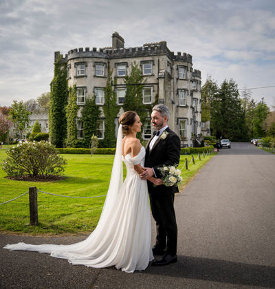 Couple embrace outside ballyseede castle wedding venue in kerry