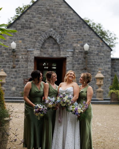 Bridesmaids and bride outside the chapel on their castle wedding day